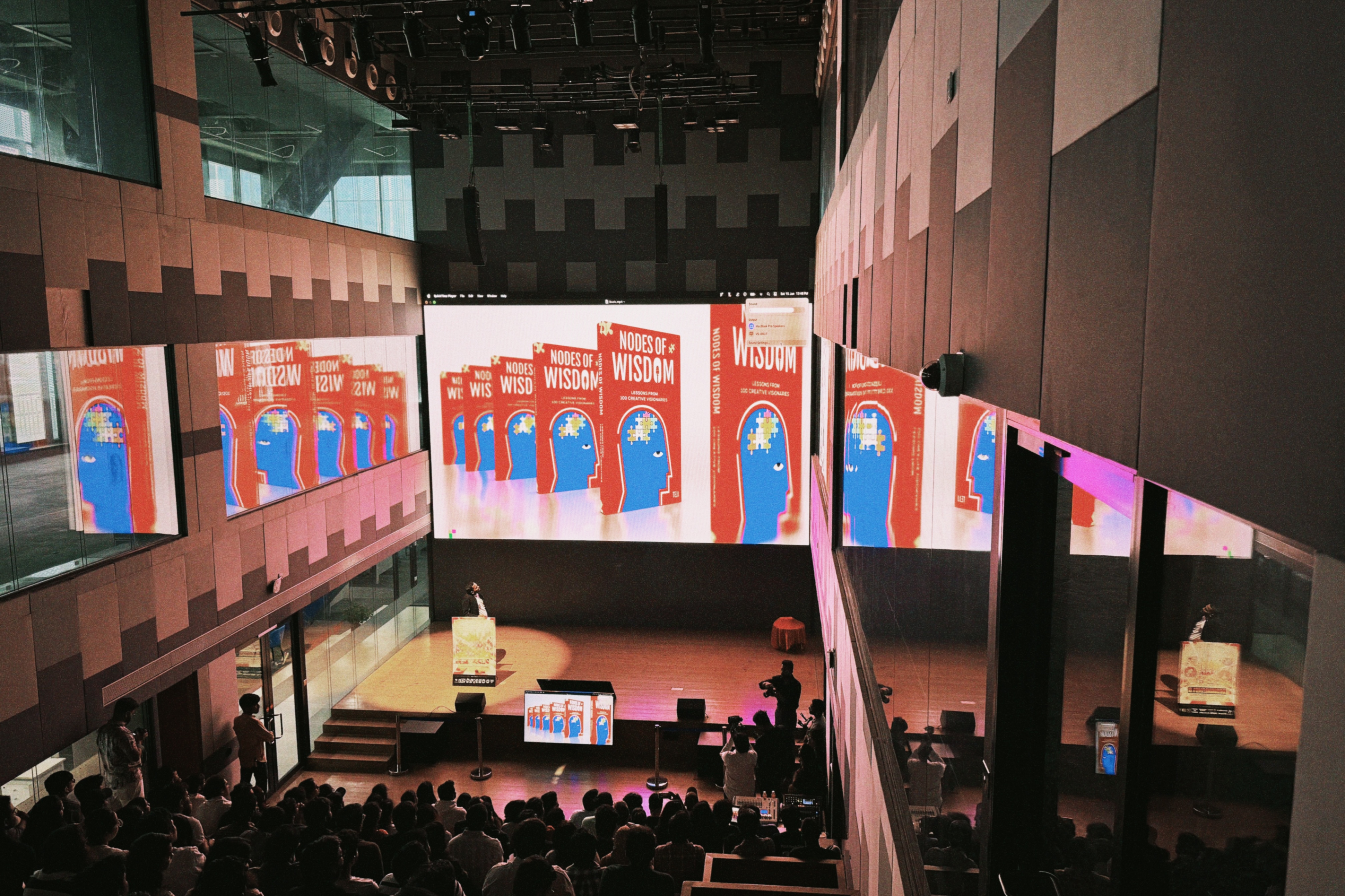 Tejj on stage at the Nodes of Wisdom launch event, speaking on creativity and design, 2024